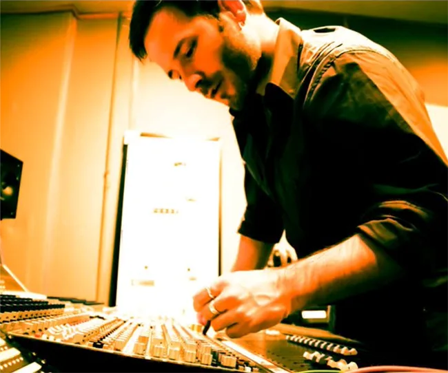Guillermo working on a mixing console in a studio